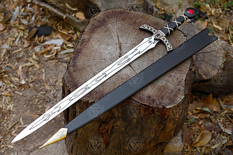 May include: A medieval sword with a silver blade and decorative patterns, a black handle with a crisscross design, and a red gem on the pommel. The sword lies on a wooden stump beside a black sheath with a gold tip.