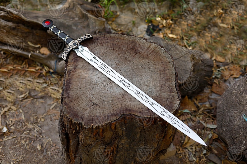 May include: A silver sword with a black handle and a red gem on the pommel rests on a wooden stump. The blade has an intricate design. The sword is a fantasy item.