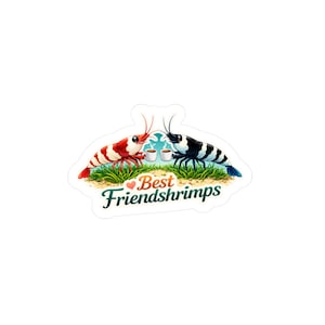 May include: A sticker featuring two cartoon shrimp, one red and white, the other black and white, facing each other. They are holding coffee cups and are on a patch of grass. The text "Best Friendshrimps" is below them.