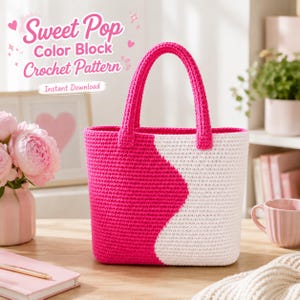 Puede incluir: Un bolso tote de ganchillo hecho a mano, con bloques de color rosa brillante y blanco. El bolso presenta un diseño curvo y asas rosas a juego. El texto de la imagen dice "Sweet Pop Color Block Crochet Pattern" y "Instant Download".