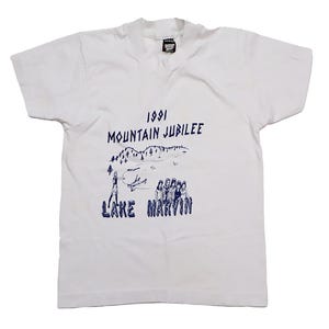 May include: White t-shirt with a blue graphic print of a mountain scene and the text "1991 Mountain Jubilee Lake Marvin".