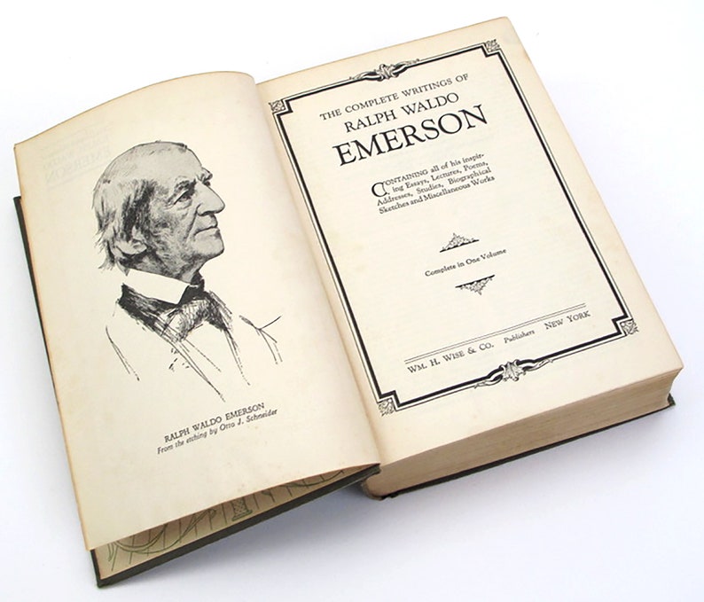 Op de afbeelding: Een open boek met een zwart-witte illustratie van Ralph Waldo Emerson op de linkerpagina. De rechterpagina heeft de titel "The Complete Writings of Ralph Waldo Emerson" en de tekst "Containing all of his inspiring Essays, Lectures, Poems, Addresses, Studies, Biographical Sketches and Miscellaneous Works. Complete in One Volume. Wm. H. Wise & Co., Publishers, New York."