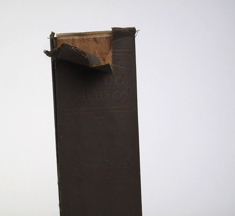 Op de afbeelding: Een bruin boek met een gescheurde kaft. De titel "A.D.  MORRISON" is zichtbaar op de rug.