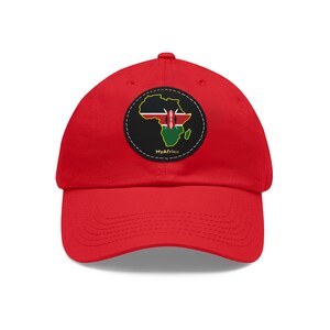 May include: A bright red baseball cap featuring a circular patch with the African continent and the Kenyan flag. The patch is outlined with a dashed white line and the text "MyAfrica" is below the continent.