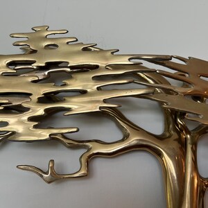 K&ouml;nnte beinhalten: Eine Baumskulptur aus Messing mit detailliertem Design. Die &Auml;ste und Bl&auml;tter des Baumes sind aufwendig geformt und erzeugen ein strukturiertes Aussehen. Die Skulptur hat eine polierte, goldene Oberfl&auml;che, die dem Kunstwerk einen Hauch von Eleganz verleiht.