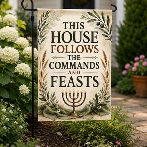 以下が含まれることがあります： THIS HOUSE FOLLOWS THE COMMANDS AND FEASTSという文字が暗い色で書かれた長方形のガーデンフラッグ。クリーム色の背景に、オリーブの枝、小麦の茎、そして火の灯ったメノーラーのイラストが描かれています。