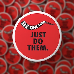 May include: A red button with white trim and the text "SIX ONE THREE COMMANDS JUST DO THEM." The text is in black and white. The background shows a blurred array of similar red buttons.