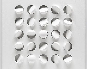 May include: A white, abstract wall art piece featuring a grid of circular, three-dimensional forms. Each circle has a curved, recessed design, creating shadows and depth. The artwork is set within a white frame, offering a minimalist aesthetic.