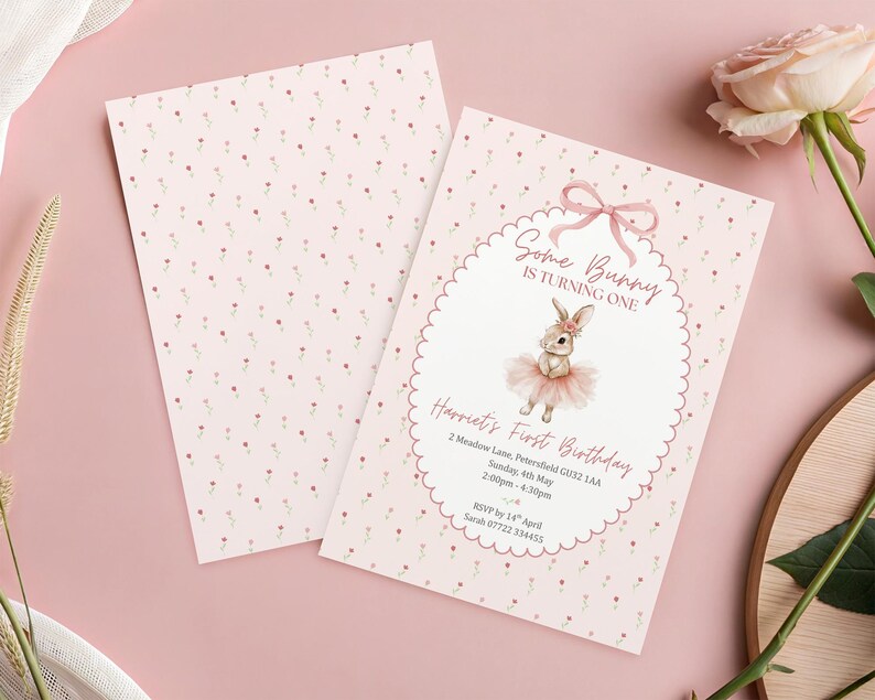 May include: Pink and white invitation card with a bunny illustration. The text reads "Some Bunny is Turning One" and includes event details. The card has a scalloped border and a floral pattern on the back.