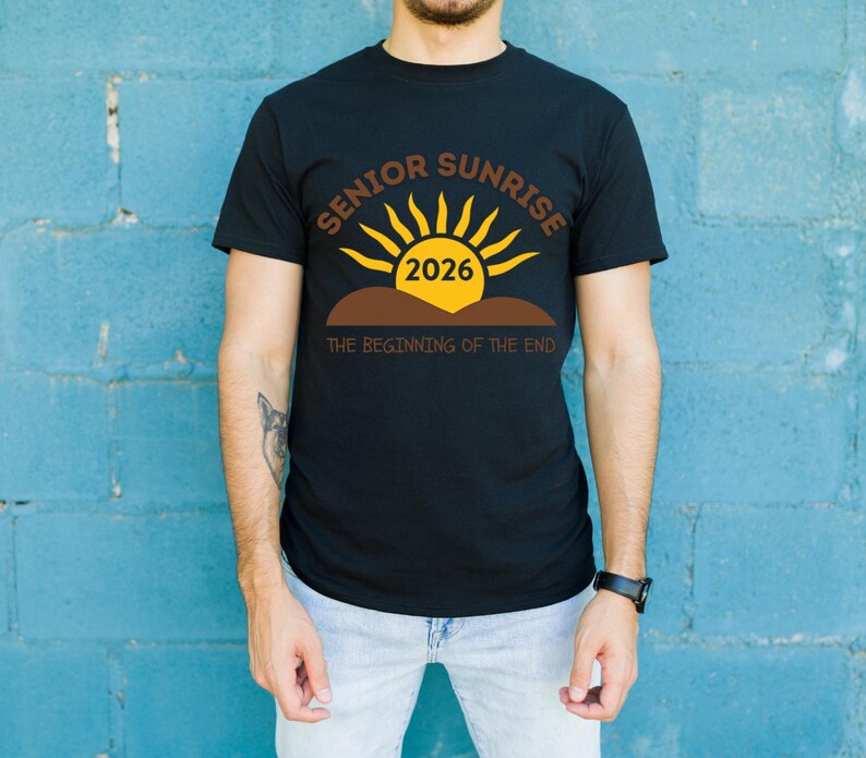 May include: Black t-shirt with a graphic design featuring the words "SENIOR SUNRISE 2026" in brown and yellow, with a sun graphic. The text "THE BEGINNING OF THE END" is below the sun graphic.