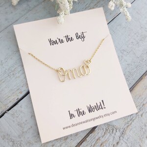 May include: Gold necklace with the word "oma" and a small heart charm. The necklace is displayed on a card that reads "You're the best Oma in the world!" and includes the website address www.deannewatsonjewelry.etsy.com.