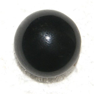 May include: A black, round, smooth, polished, glass bead.