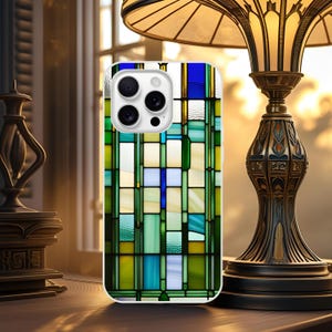 Op de afbeelding: Een witte smartphonehoes met een glas-in-loodontwerp in groen, blauw en geel. De hoes heeft een glanzende afwerking en een camera-uitsparing. Het ontwerp lijkt op een geometrisch patroon.