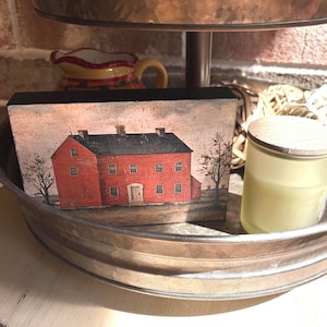 Primitive country decor block with red colonial farmhouse artwork, distressed vintage finish, and rustic Americana style displayed on a tiered tray.