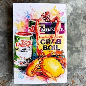 May include: Watercolor-style wood block featuring Tony Chachere's Creole Seasoning and Zatarain's Crab Boil boxes, with crawfish and a lemon. The image includes text: "Crawfish, Shrimp and Crab Boil". The seasoning can reads "Net Wt. 6 oz. 227 grams".