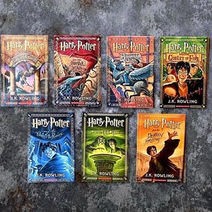 May include: A collection of seven Harry Potter books by J.K. Rowling, featuring illustrated covers for Sorcerer's Stone, Chamber of Secrets, Prisoner of Azkaban, Goblet of Fire, Order of the Phoenix, Half-Blood Prince, and Deathly Hallows.