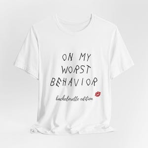 May include: White t-shirt with black text that reads "On My Worst Behavior bachelorette edition" and a red lip print.