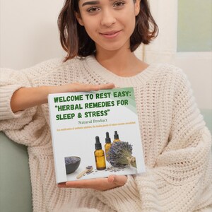 Puede incluir: Una mujer sostiene un libro titulado "WELCOME TO REST EASY: 'HERBAL REMEDIES FOR SLEEP & STRESS' Natural Product." El libro presenta im&aacute;genes de botellas de aceites esenciales, lavanda y una cuchara de madera. La mujer lleva un su&eacute;ter color crema.