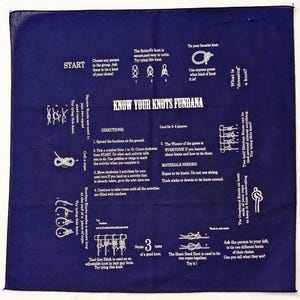 K&ouml;nnte beinhalten: Ein blaues Bandana mit wei&szlig;em Text und Illustrationen verschiedener Knoten. Das Bandana tr&auml;gt den Titel "Know Your Knots Fundana" und enth&auml;lt Anweisungen f&uuml;r ein Knotenspiel.