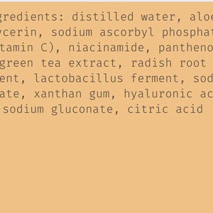 May include: A tan background displays a list of ingredients in a skincare product. The text includes distilled water, aloe, glycerin, vitamin C, niacinamide, panthenol, green tea extract, and other components.