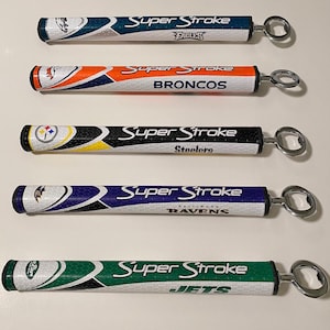 May include: Five Super Stroke bottle openers with team logos. The openers feature the Eagles, Broncos, Steelers, Ravens, and Jets. Each opener has a silver bottle opener attached to the end.