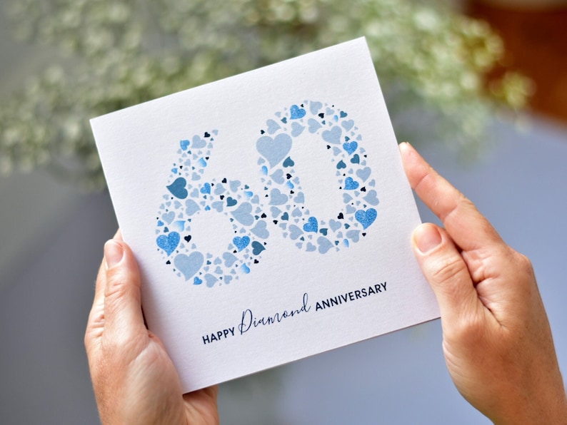Diamond 60th Wedding Anniversary card. The number 60 is made from a collection of blue love hearts. Underneath the large number 60 are the words "Happy Diamond Anniversary".