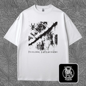 May include: White t-shirt with a black graphic design. The design features a beetle, abstract shapes, and the text "Feeling Kafkaesque." A small square logo with a winged lion and the words "Nocturnal Academy" is in the lower right corner.