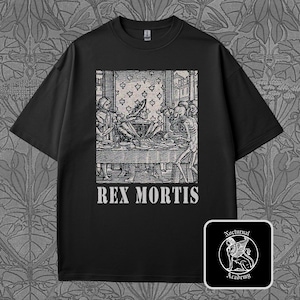 Pode incluir: Camiseta preta com uma ilustração em preto e branco de um banquete medieval com figuras esqueléticas e o texto "REX MORTIS". Um pequeno logotipo quadrado com um leão alado está no canto inferior direito.