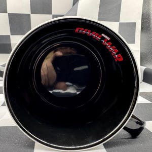 Puede incluir: Taza de cer&aacute;mica negra con borde y asa blancos. El interior es negro y las palabras "CAPTAIN AMERICA CIVIL WAR" est&aacute;n impresas en rojo. La taza est&aacute; sobre una superficie a cuadros blancos y negros.