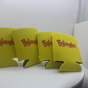 May include: Four bright yellow foam can coolers arranged in a row. Each cooler features the red Bojangles logo printed on the front, including a small star above the letter j. The foam material is flexible and designed to insulate beverage cans.