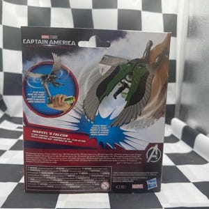 May include: Marvel's Falcon action figure packaging. The box features the Captain America logo and a depiction of the Falcon with green and gray wings. The packaging includes the Marvel logo and the number 43381.