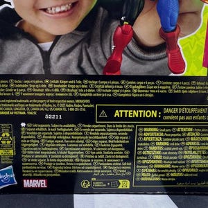 May include: A Marvel action figure box featuring a child's smiling face. The box includes text, a warning about small parts, and the Hasbro and Marvel logos. The figure's red boots and blue legs are visible.