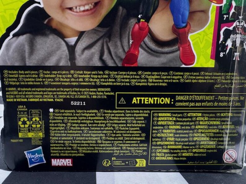 May include: A Marvel action figure box featuring a child's smiling face. The box includes text, a warning about small parts, and the Hasbro and Marvel logos. The figure's red boots and blue legs are visible.