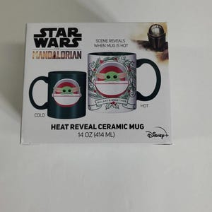 Pode incluir: Caneca de cer&acirc;mica Star Wars Mandalorian com revela&ccedil;&atilde;o de calor. A caneca apresenta Grogu, tamb&eacute;m conhecido como Baby Yoda, com um design que muda quando aquecido. A caneca tem 414 ml e o logotipo da Disney+.