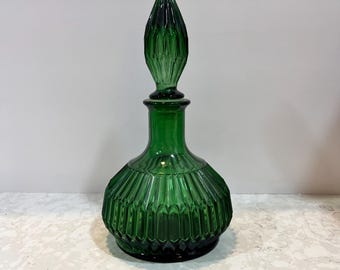 May include: A green glass decanter with a textured, ribbed body and a pointed, ribbed stopper.