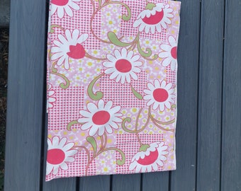 May include: Pink and white fabric with a gingham pattern and large white flowers with pink centers. The fabric has a vintage style.