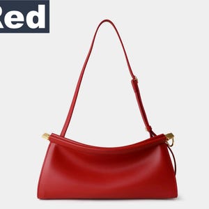 May include: A bright red handbag with a long, thin strap and gold-colored hardware. The bag has a rectangular shape with a curved top and a single handle. The word "Red" is in a white font on a dark blue background.