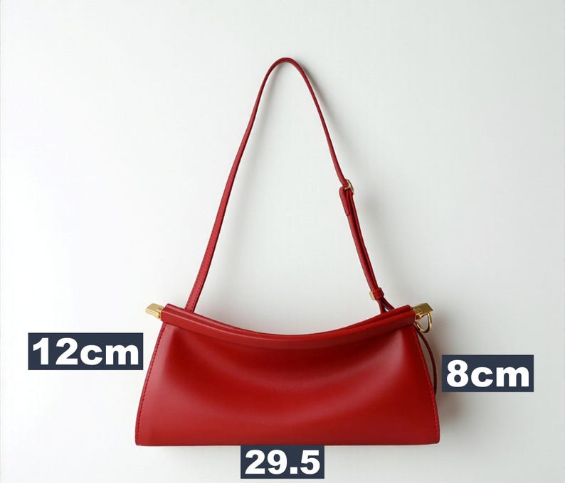 May include: A red handbag with a shoulder strap. The bag is 29.5 cm long, 12 cm high, and 8 cm wide. The bag has gold-colored accents on the handle attachments.