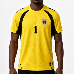 Pode incluir: Uma camisola de manga curta amarelo-brilhante com pain&eacute;is laterais e riscas nos ombros pretas. A frente apresenta um n&uacute;mero 1 preto proeminente no centro, um pequeno emblema de equipa desfocado no peito e uma pequena etiqueta preta.