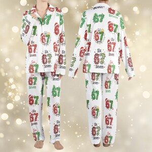May include: White pyjama set featuring the numbers 67, Christmas lights, and the words "Six" and "Seven" in red and green. The long-sleeved top and trousers are visible, with the pattern repeating.