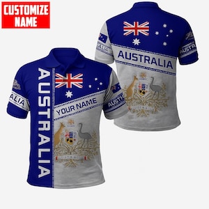 Könnte beinhalten: Ein blau-graues Poloshirt mit dem Wort "AUSTRALIA" vertikal auf der Vorder- und Rückseite aufgedruckt. Das Shirt zeigt die australische Flagge und ein Wappen-Design. Der Text "YOUR NAME" ist ebenfalls sichtbar.