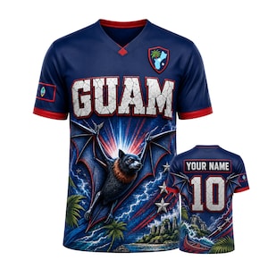 May include: A navy blue V-neck jersey featuring the word GUAM in white cracked lettering, a flying fruit bat graphic, palm trees, and lightning. The back displays the text YOUR NAME and the number 10 in white with red trim and a bat wing design.