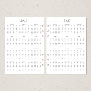 K&ouml;nnte beinhalten: Zwei wei&szlig;e Planerseiten mit Kalendern f&uuml;r die Jahre 2026 und 2027. Jede Seite hat ein Kalenderraster mit Monaten und Tagen. Die Seiten sind mit L&ouml;chern zum Binden vorgestanzt.