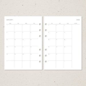 Pode incluir: Duas p&aacute;ginas de um calend&aacute;rio mensal de 2026. A p&aacute;gina esquerda est&aacute; rotulada como "Janeiro" e a direita como "2026". Cada p&aacute;gina tem uma grade de quadrados para datas, com furos perfurados no lado esquerdo para encaderna&ccedil;&atilde;o.