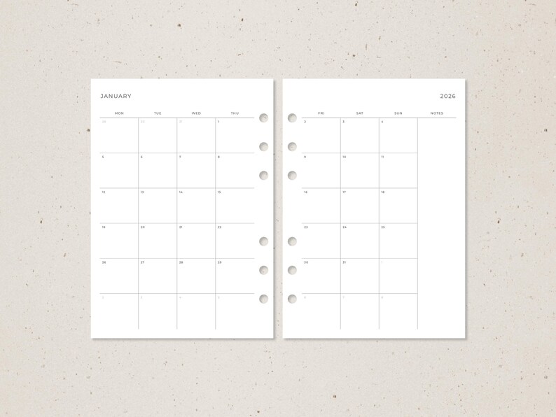 Pode incluir: Duas p&aacute;ginas de um calend&aacute;rio mensal de 2026. A p&aacute;gina esquerda est&aacute; rotulada como "Janeiro" e a direita como "2026". Cada p&aacute;gina tem uma grade de quadrados para datas, com furos perfurados no lado esquerdo para encaderna&ccedil;&atilde;o.