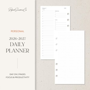 Op de afbeelding: Een persoonlijke dagplanner voor 2026-2027 met een minimalistisch ontwerp. De planner bevat pagina's voor dagelijkse planning, prioriteiten en takenlijsten. Het ontwerp toont de tekst "Paper Seasons Co" en "Day on 2 Pages Focus & Productivity."