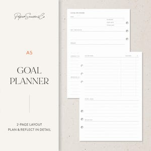 May include: A white A5 goal planner with a 2-page layout. The planner includes sections for goals, motivation, rewards, action steps, and reflection. The text "GOAL PLANNER" is prominently displayed.