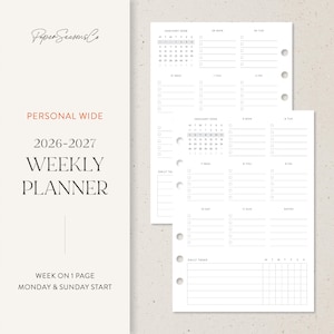 May include: A white 2026-2027 weekly planner with a minimalist design. The planner includes a calendar, daily task sections, and a week-on-one-page layout. The text "Paper Seasons Co" and "Personal Wide" are visible.