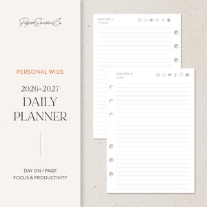 May include: A white personal wide daily planner for 2026-2027 with lined pages. The planner includes the text "Paper Seasons Co", "Personal Wide", "Daily Planner", and "Day on 1 Page Focus & Productivity". The pages are dated January 1 and January 2.