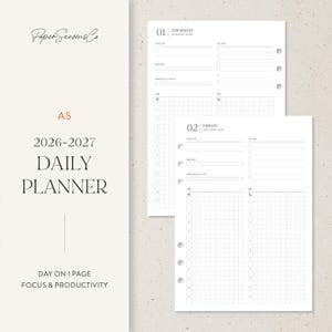 Può includere: Agenda giornaliero A5 dal design minimalista. L'agenda include sezioni per concentrazione, umore e produttività, con un layout a griglia per la gestione del tempo. La copertina mostra il testo "2026-2027 DAILY PLANNER".